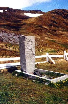 Shackleton&rsquo;s gravestone in South Georgia, a weathered stone monument set in a remote cemetery landscape, symbolizing his enduring legacy as a leader who prioritized human resilience and survival over material success. The grave reflects the stark, isolated environment of the Southern Ocean region where Shackleton&rsquo;s greatest achievements unfolded.